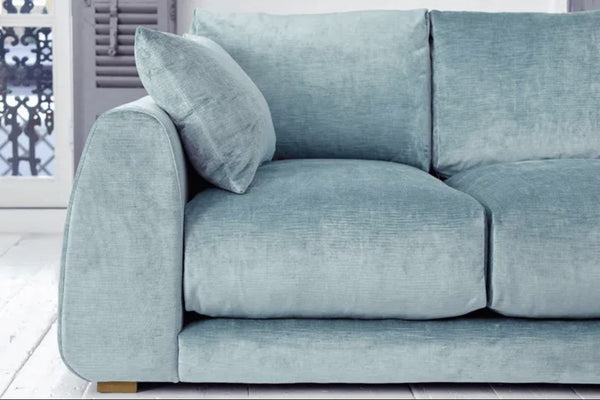 Carmel Contemporary Curved Sofa with soft curved lines and plush feather-wrapped cushions in modern living room setting